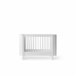 The bed has a simple, white design with a lattice front and rounded corners.